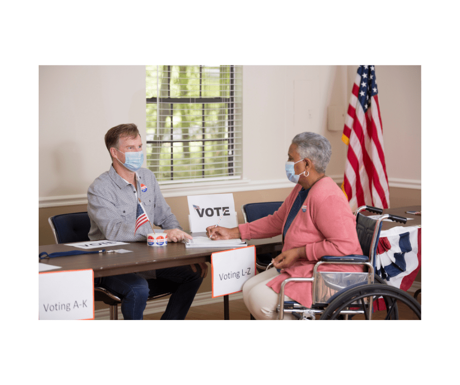 a voter and election worker at a check-in table